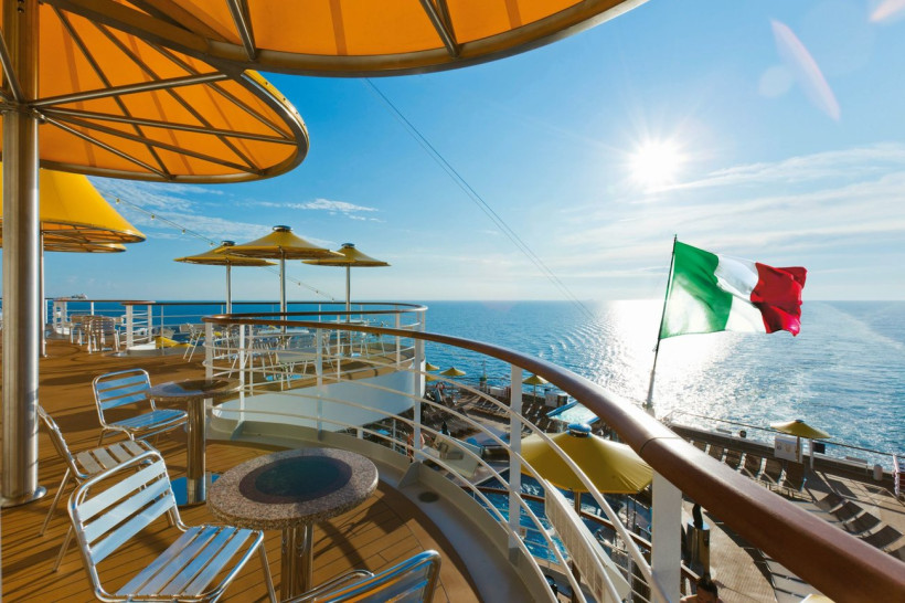 Costa Fascinosa: Sonnendeck mit Sonnenschirmen und Meerblick Sonnendeck der Costa Fascinosa mit Sitzgelegenheiten, Sonnenschirmen und Blick auf das Meer; italienische Flagge im Vordergrund