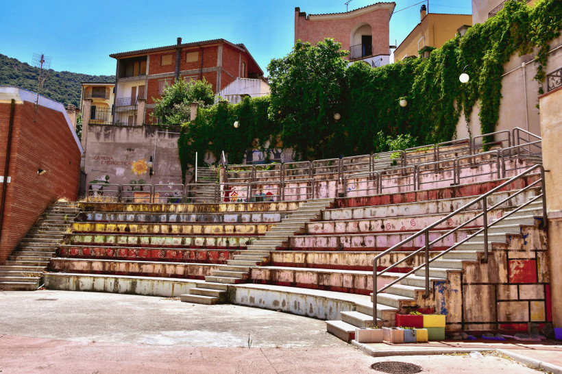 Freiluft-Amphitheater in Orgosolo auf Sardinien mit bunten Häusern und grüner Umgebung – authentisches Bergdorf im Herzen der Insel, bekannt für Wandmalereien