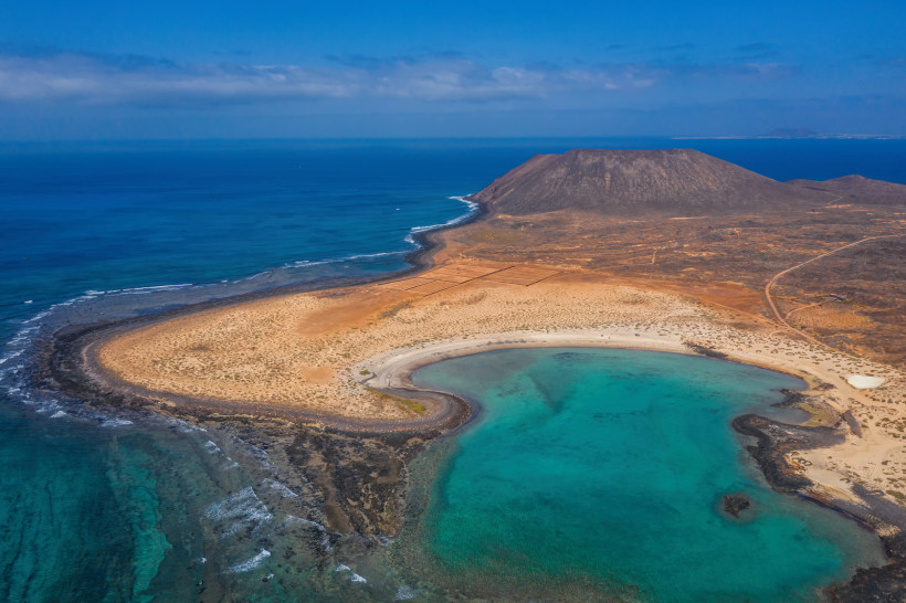 Luftaufnahme der Insel Lobos mit türkisfarbener Lagune, Sandstrand und vulkanischer Landschaft
