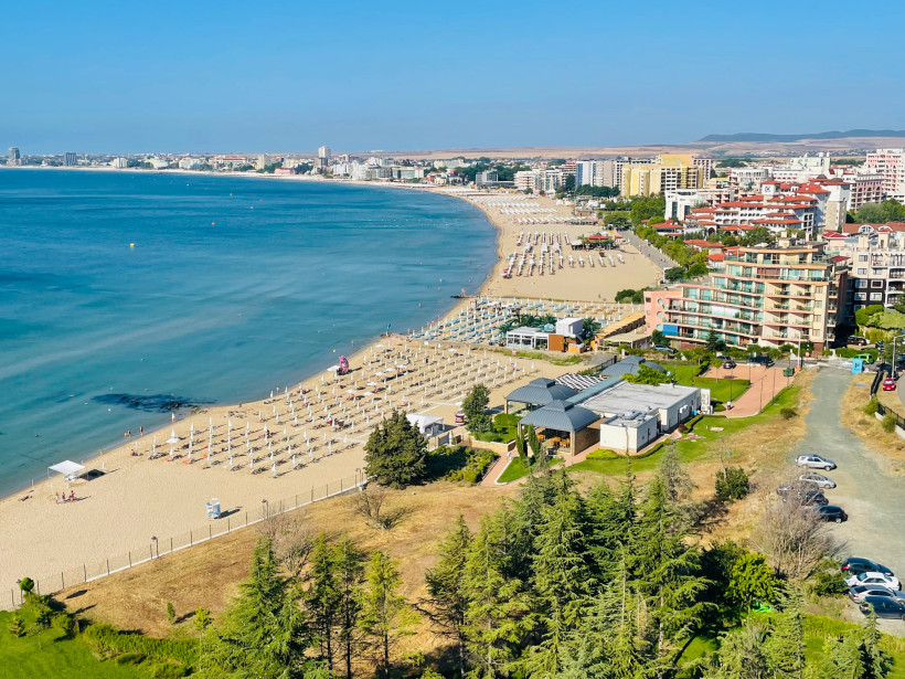 Preisbewusster All Inclusive Urlaub an einem langen Sandstrand mit zahlreichen Hotels, Strandliegen und Promenade – ideales Reiseziel für günstige Pauschalreisen.
