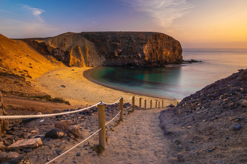 Playa de Papagayo bei Sonnenuntergang – goldene Bucht im Süden von Lanzarote Sonnenuntergang am Playa de Papagayo auf Lanzarote mit golden beleuchteter Felsbucht und türkisfarbenem Meer im Süden der Insel.