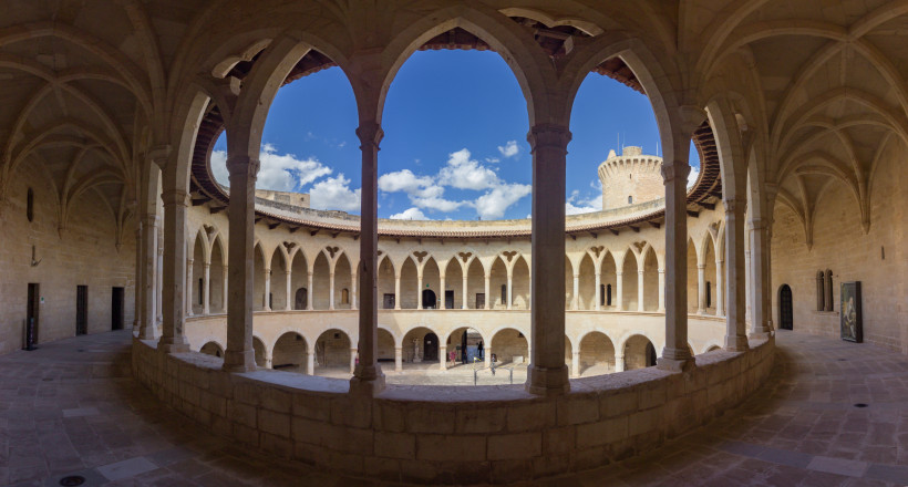 Innenhof des Castell de Bellver mit zweigeschossigen Arkaden und Blick auf den runden Turm