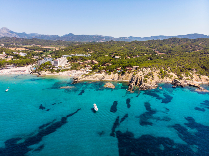 Costa de la Calma in Calvia – Felsige Badebucht mit klarem Wasser Luftaufnahme der Costa de la Calma in der Gemeinde Calvia mit türkisblauem Wasser, felsiger Küste, kleiner Badezone und bewaldeten Hügeln im Südwesten Mallorcas.