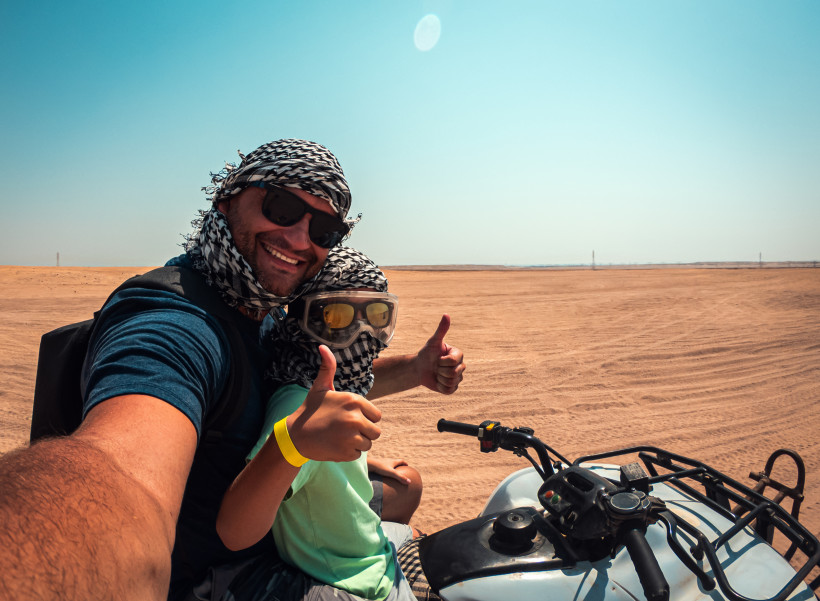 Erwachsener und Kind auf einem Quad in der Wüste – erlebnisreicher Familienurlaub mit Abenteuerausflug