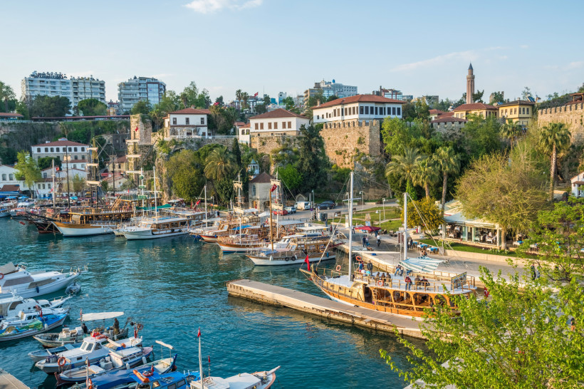 Kaleici Hafen in Antalya – Historischer Yachthafen und Altstadtflair Historischer Hafen von Kaleiçi in Antalya mit traditionellen Ausflugsbooten, Palmen und Altstadthäusern oberhalb der Felsküste – beliebtes Ausflugsziel an der Türkischen Riviera