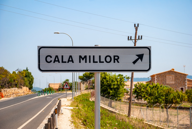 Ortsschild von Cala Millor an einer Straße auf Mallorca mit blauem Himmel im Hintergrund