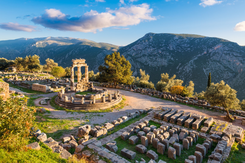 Griechenland - Delphi Ruinen des Tholos von Delphi in Griechenland, umgeben von Bergen und grüner Landschaft