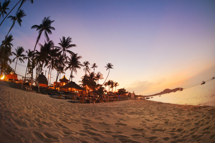 Bophut Beach Koh Samui – Sonnenuntergang mit Palmen Stimmungsvoller Sonnenuntergang am Bophut Beach auf Koh Samui, Thailand, mit Palmen, Strandbars und Booten im Meer.