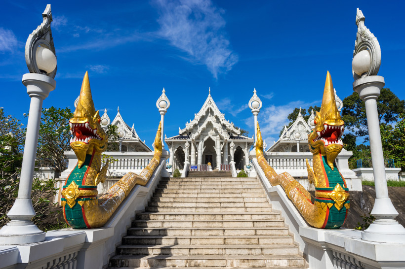 Treppenaufgang mit goldenen Naga-Skulpturen zum Wat Kaew Tempel in Krabi, Thailand.