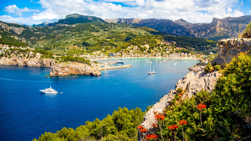 Blick vom Wanderweg auf den Port de Sóller mit Bucht, Booten und dem Tramuntana-Gebirge im Hintergrund