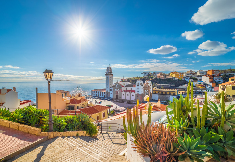 Candelaria Teneriffa Sehenswürdigkeiten – Treppenblick zur Basilika am Meer Sonniger Blick über die Treppen von Candelaria auf Teneriffa hinunter zur Basilika Nuestra Señora de la Candelaria, umgeben von bunten Häusern, Kakteen und dem glitzernden Atlantik.