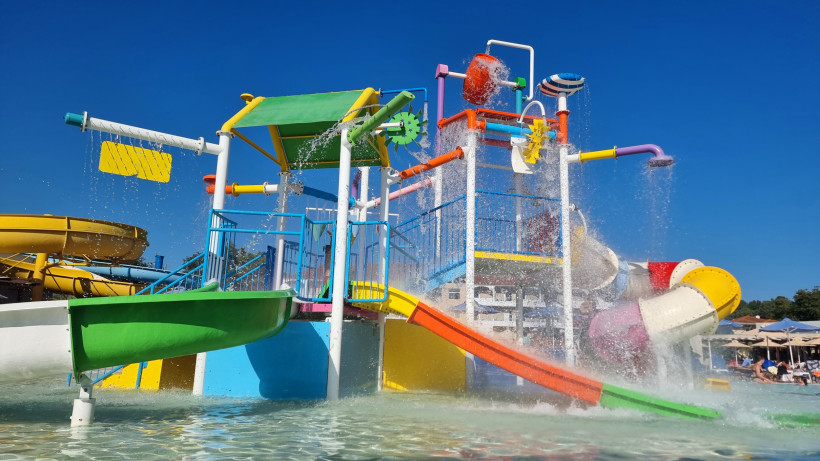 Familienfreundliches Hotel mit Wasserpark und Rutschen an Kretas Nordküste Buntes Wasserspielgerät mit Rutschen und Wasserfontänen in einem Hotelpool an Kretas Nordküste