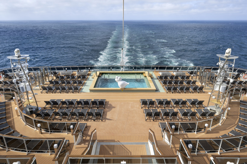 MSC Euribia: Horizon Pool am Heck mit umliegenden Liegestühlen und Blick auf das Meer Horizon Pool auf dem Kreuzfahrtschiff MSC Euribia mit Liegestühlen am Heck und Blick auf die Heckwelle