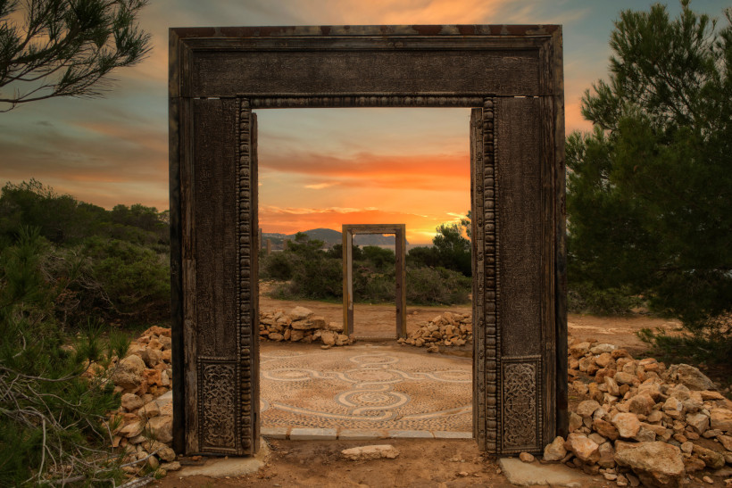 Puertas de Llentia auf Ibiza bei Sonnenaufgang Rahmenförmiges Holztor der Puertas de Llentia auf Ibiza bei Sonnenaufgang