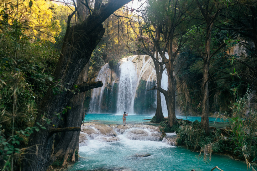 Wasserfall in Jamaika mit türkisfarbenem Naturpool, umgeben von Bäumen