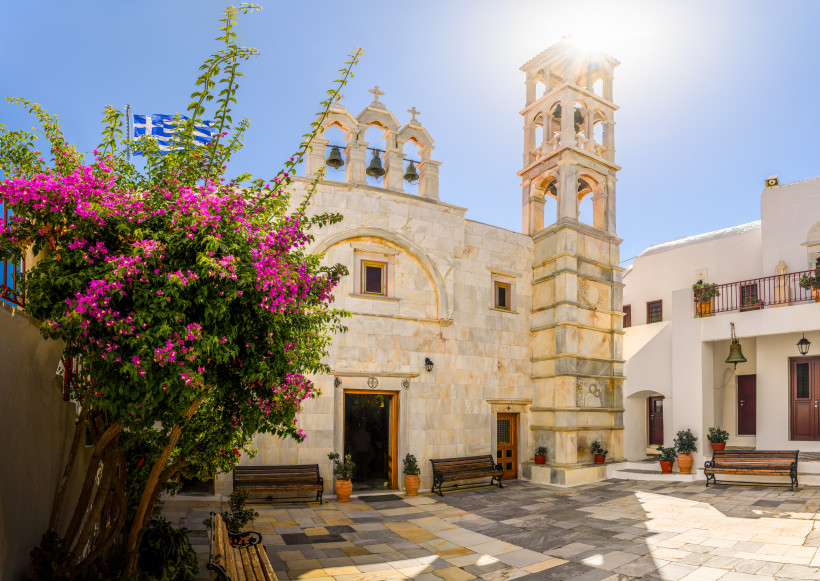 Mykonos - Ano Mera Innenhof des Klosters Panagia Tourliani in Ano Mera auf Mykonos mit Glockenturm, Steinbänken und blühender Bougainvillea