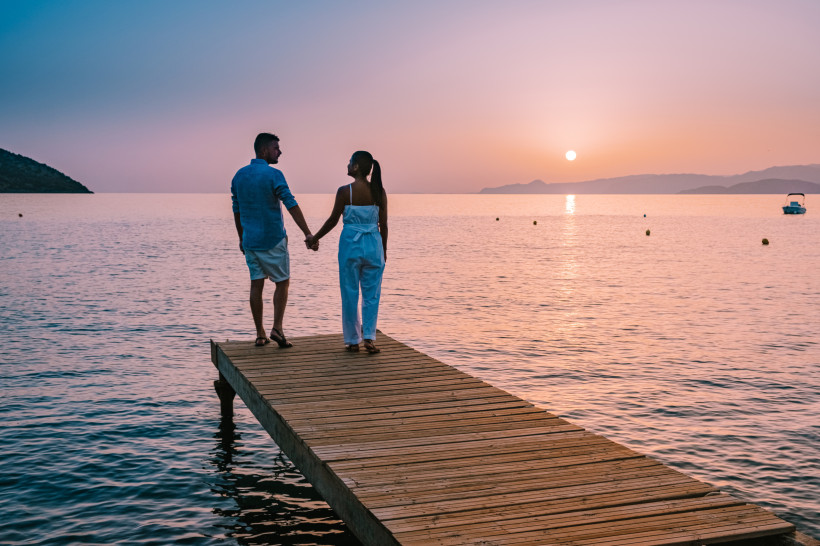 Stalida: Entspannte Abende am Meer genießen Paar bei Sonnenuntergang am Meer auf Kreta – entspannte Urlaubsatmosphäre für Paare wie in Stalida