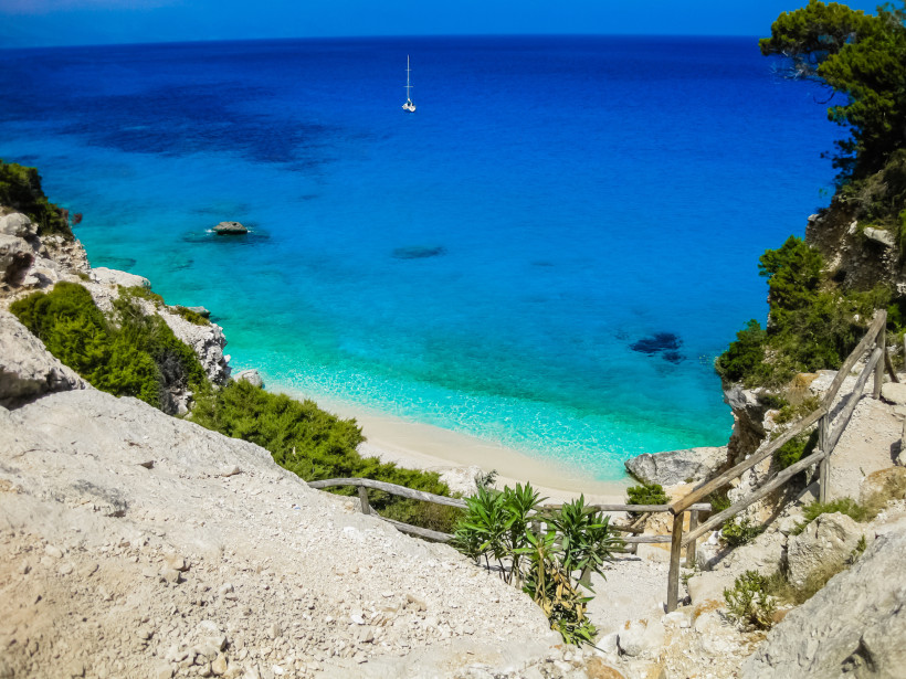 Atemberaubender Blick auf die Cala Goloritzé auf Sardinien mit türkisblauem Meer, weißem Sandstrand und steilen Felsen – einer der schönsten Strände Italiens an der Ostküste Sardiniens.