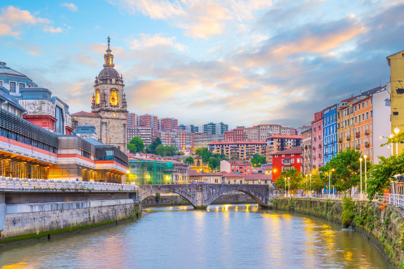 Bilbao: Ribera-Markt am Fluss mit Brücke, Kirchturm und farbenfrohen Ufergebäuden
