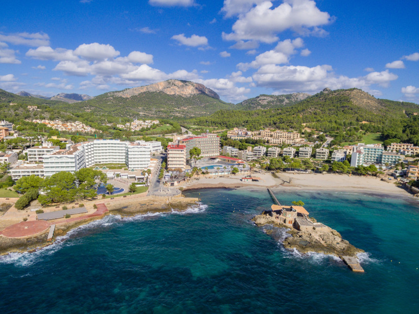 Bucht von Camp de Mar mit Sandstrand, Steg zum Inselrestaurant La Illeta und Hotels entlang der Küste