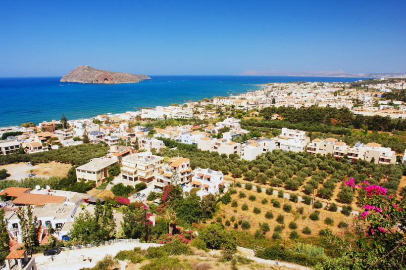 Blick über Platanias bei Chania auf Kreta mit Küste, Häusern und Insel im Meer