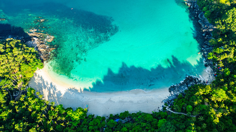 Freedom Beach Phuket aus der Vogelperspektive – Türkises Wasser und Dschungel Luftaufnahme des Freedom Beach auf Phuket mit kristallklarem Wasser, weißem Sandstrand und umgebendem tropischen Regenwald.