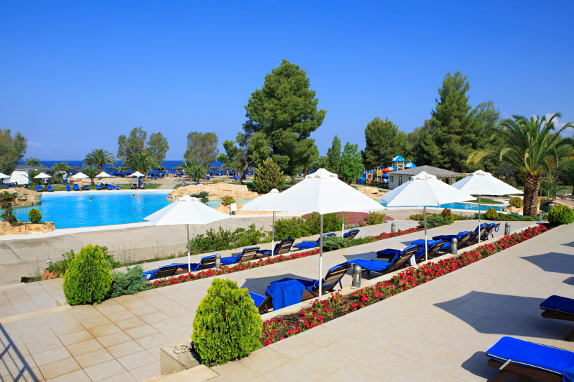 Poolanlage eines Resorts auf Kreta mit Liegen und Sonnenschirmen