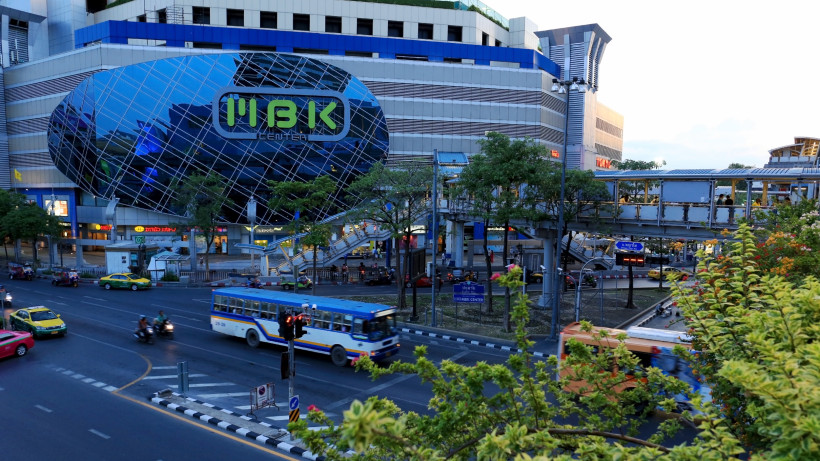 MBK Center Bangkok – Beliebtes Einkaufszentrum mit Elektronik, Mode und Streetfood Außenansicht des MBK Centers in Bangkok mit Straßenverkehr und Skywalk