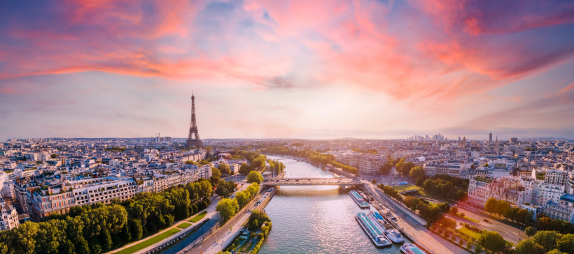 Paris Weitwinkel-Panorama von Paris bei Sonnenuntergang: die Seine durchschneidet die Stadt, in der Mitte der Eiffelturm; Uferpromenaden, Brücken und Hausdächer unter rosa Wolken