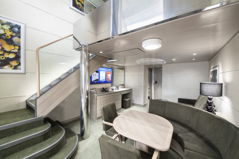 MSC Grandiosa – MSC Yacht Club Duplex Suite (YJD), Wohn- und Essbereich Wohn- und Essbereich einer MSC Yacht Club Duplex Suite auf der MSC Grandiosa mit Treppe zur oberen Ebene