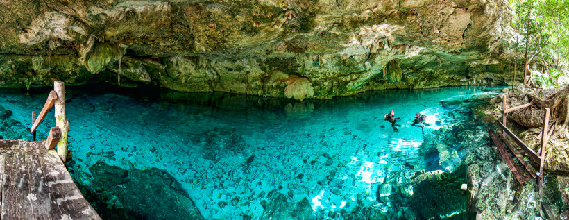 Zwei Taucher erkunden eine Cenote in Mexiko – Höhle mit glasklarem Wasser und Felsen, beliebtes Ausflugsziel auf der Halbinsel Yucatán 2025/2026