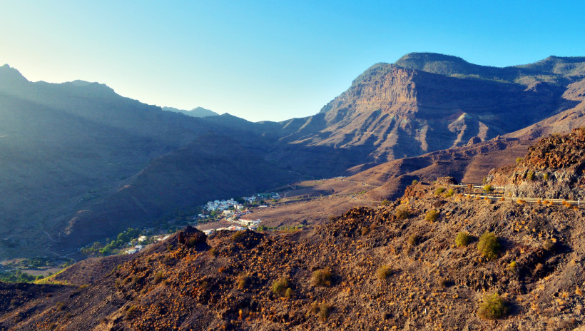 Valle de Veneguera: Gebirgstal mit felsigen Hängen und Siedlung im Tal Blick über das Valle de Veneguera mit felsigen Berghängen und kleinem Ort im Tal