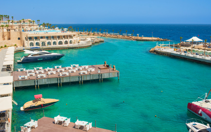 Moderne Marina mit türkisblauem Wasser, Restaurants auf der Terrasse und eleganten Yachten im Hafen