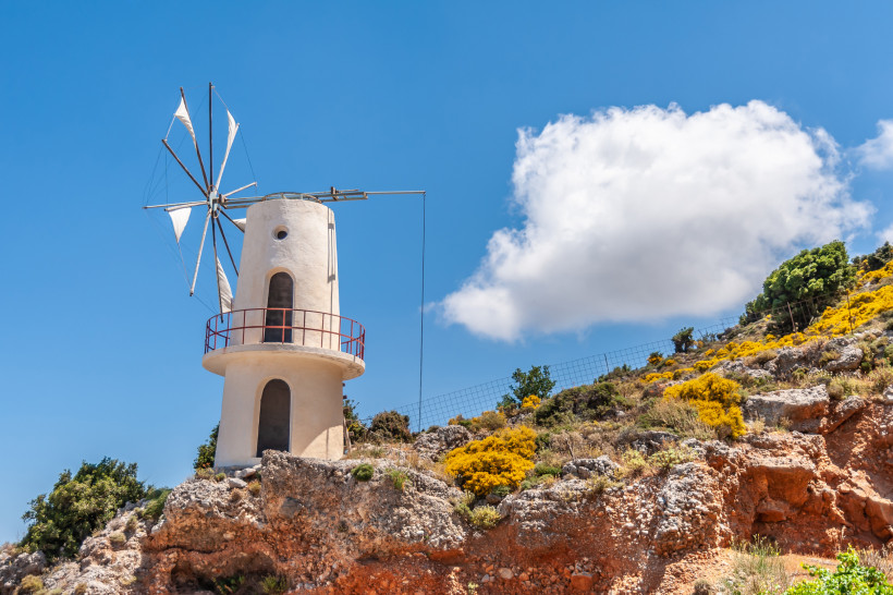 Windmühle an der Lasithi-Hochebene auf Kreta Windmühle auf felsigem Hang an der Lasithi-Hochebene unter blauem Himmel
