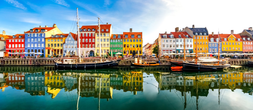 Nyhavn in Kopenhagen mit historischen Häusern und Booten am Hafenbecken Bunte Häuserfassaden am Hafen Nyhavn in Kopenhagen mit Segelbooten im Vordergrund