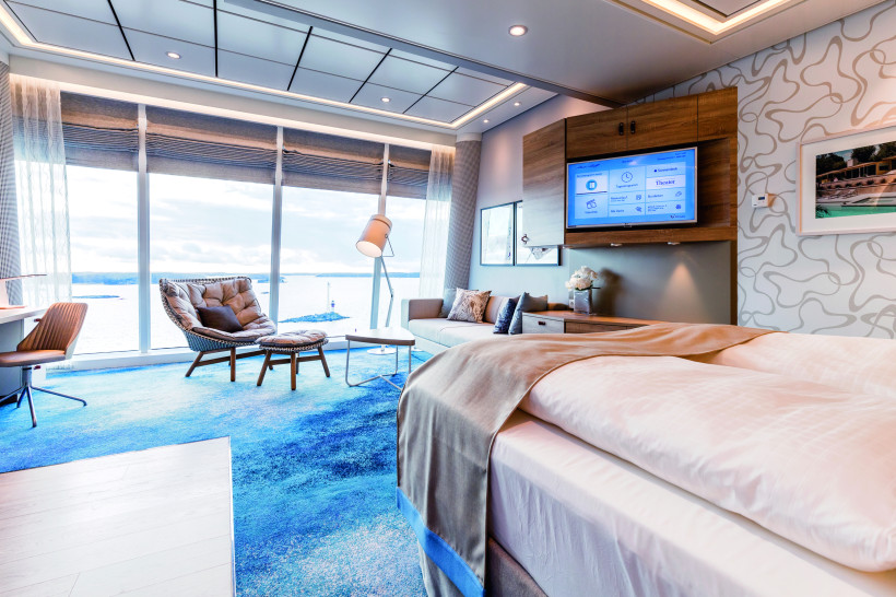 Wohnbereich der Himmel & Meer Suite auf Mein Schiff 6 mit Panoramafenstern und Meerblick