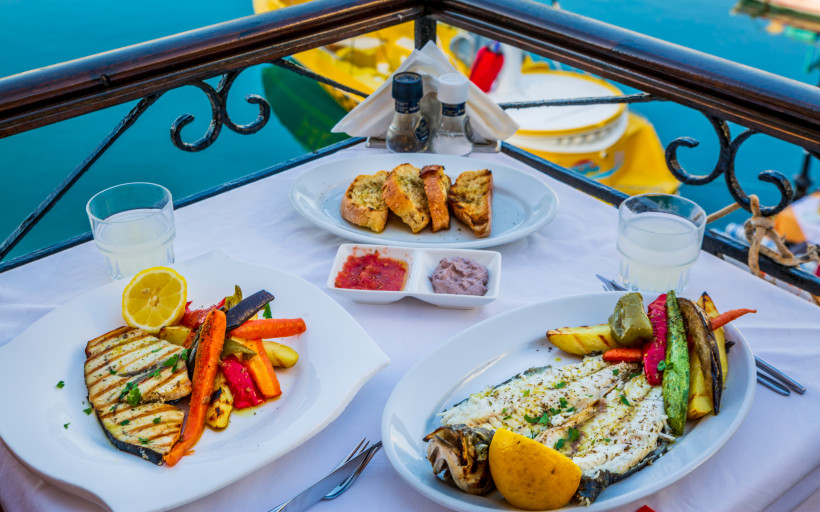 Abendessen in Heraklion: gegrillter Fisch und Gemüse auf einem Tisch am Hafen