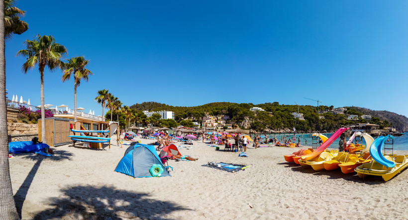Familien am Sandstrand von Camp de Mar mit Tretbooten und flachem Wasser – ideal für sicheren Badeurlaub mit Kindern