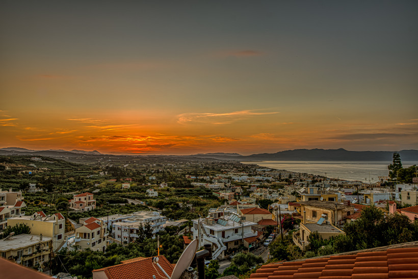 Platanias für Paare: Panorama der Ortschaft und Küstenlinie bei Sonnenuntergang Blick über Platanias mit Küste und Bergen bei Sonnenuntergang