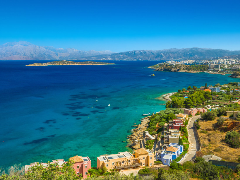 Panoramablick über die Mirabello-Bucht bei Agios Nikolaos mit türkisblauem Meer, Küstenlinie und Insel im Hintergrund
