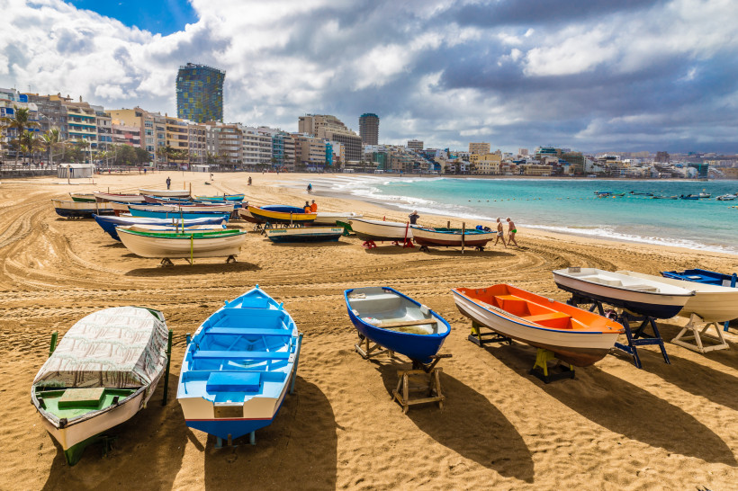 Fischerboote auf dem Sandstrand vor der Stadtpromenade von Las Palmas de Gran Canaria