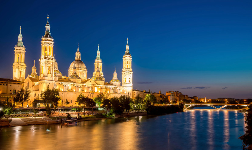 Basilika in Saragossa bei Nacht am Ufer des Ebro, beleuchtete Türme und Kuppeln