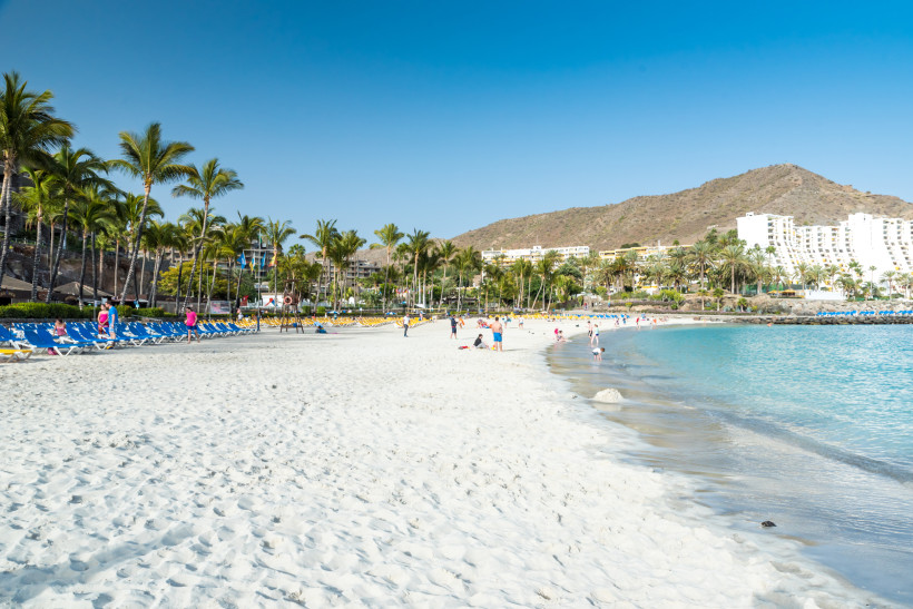 Playa de Amadores auf Gran Canaria Der weiße Sandstrand Playa de Amadores auf Gran Canaria mit Palmen, Sonnenliegen und türkisblauem Wasser – ein beliebter Badeort für Familien und Sonnenhungrige.