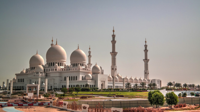 Außenansicht der Sheikh-Zayed-Moschee in Abu Dhabi mit weißen Kuppeln und Minaretten