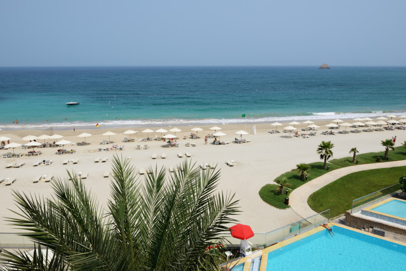 Fujairah, Strandferien Luxuriöser Strand mit Sonnenschirmen, Liegen und Poolanlage mit Blick auf das blaue Meer