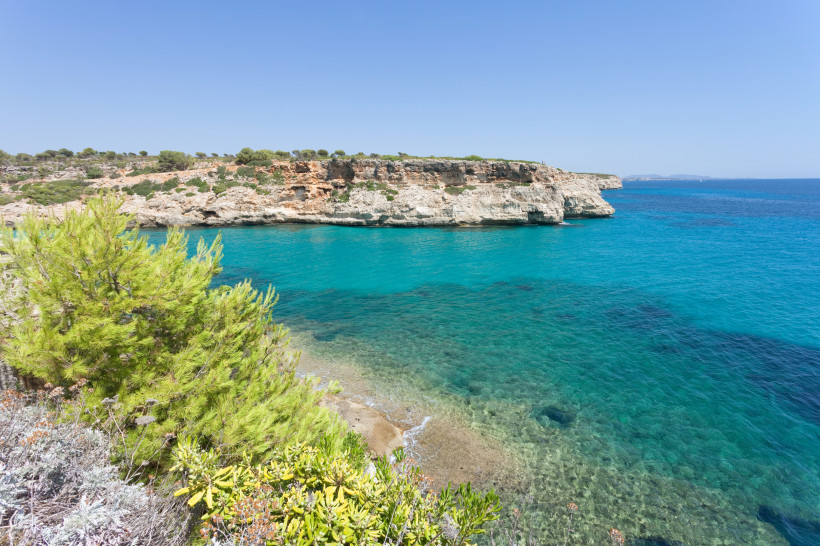 Felsige Steilküste bei Calas de Mallorca mit klarem Wasser und natürlicher Vegetation oberhalb der Badebuchten an der Ostküste Mallorcas.