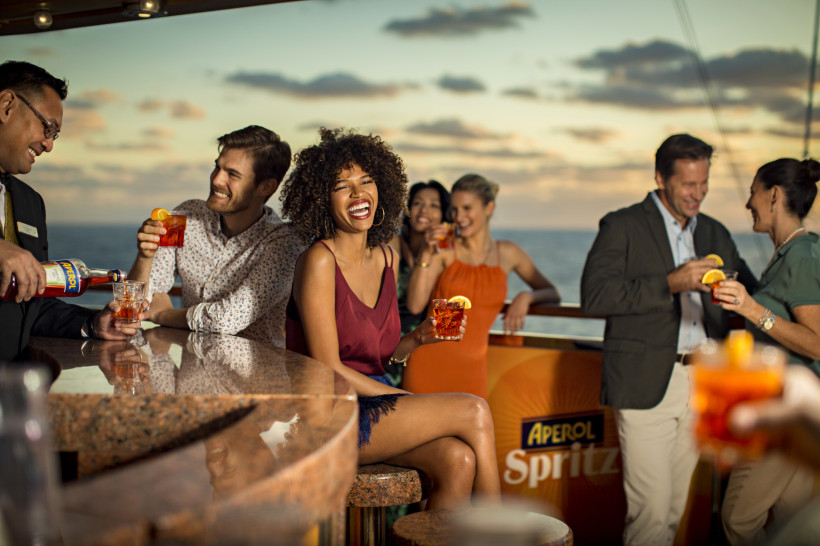 Costa Diadema: Aperol-Spritz-Bar an Deck mit Gästen und Meerblick Aperol-Spritz-Bar an Bord der Costa Diadema mit Gästen und Blick auf das Meer bei Sonnenuntergang