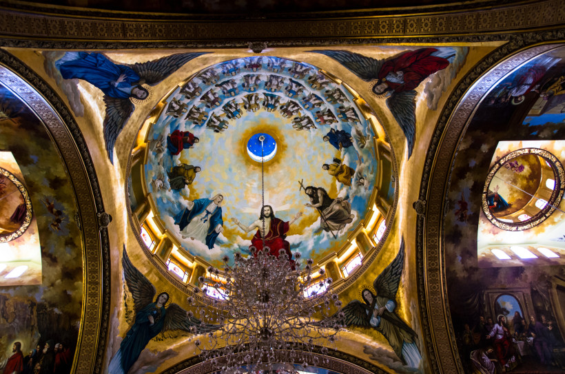 Ägypten - Sharm el Sheikh Blick in eine bemalte Kirchenkuppel mit einer Darstellung Christi in der Mitte, umgeben von Maria, Johannes dem Täufer und zahlreichen Heiligenfiguren sowie Engeln. Die Szene ist himmlisch inszeniert, mit goldener Umrahmung und detailreichen Fresken. Ein