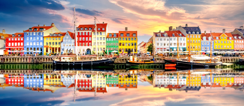 Nyhavn, Kopenhagen, Dänemark – bunte Häuserfront am Kanal mit Booten Nyhavn in Kopenhagen, Dänemark, mit bunten Hafenhäusern und Segelbooten am Kanal bei Abendlicht