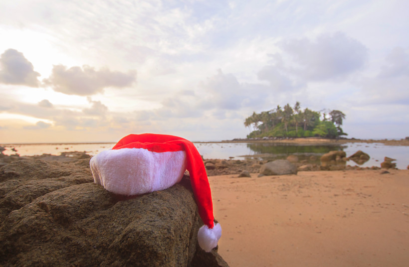 Weihnachten in Phuket – Weihnachtsmütze am tropischen Strand in Thailand Weihnachtsmütze auf Felsen am Strand von Phuket bei Sonnenuntergang – tropisches Weihnachten in Thailand.